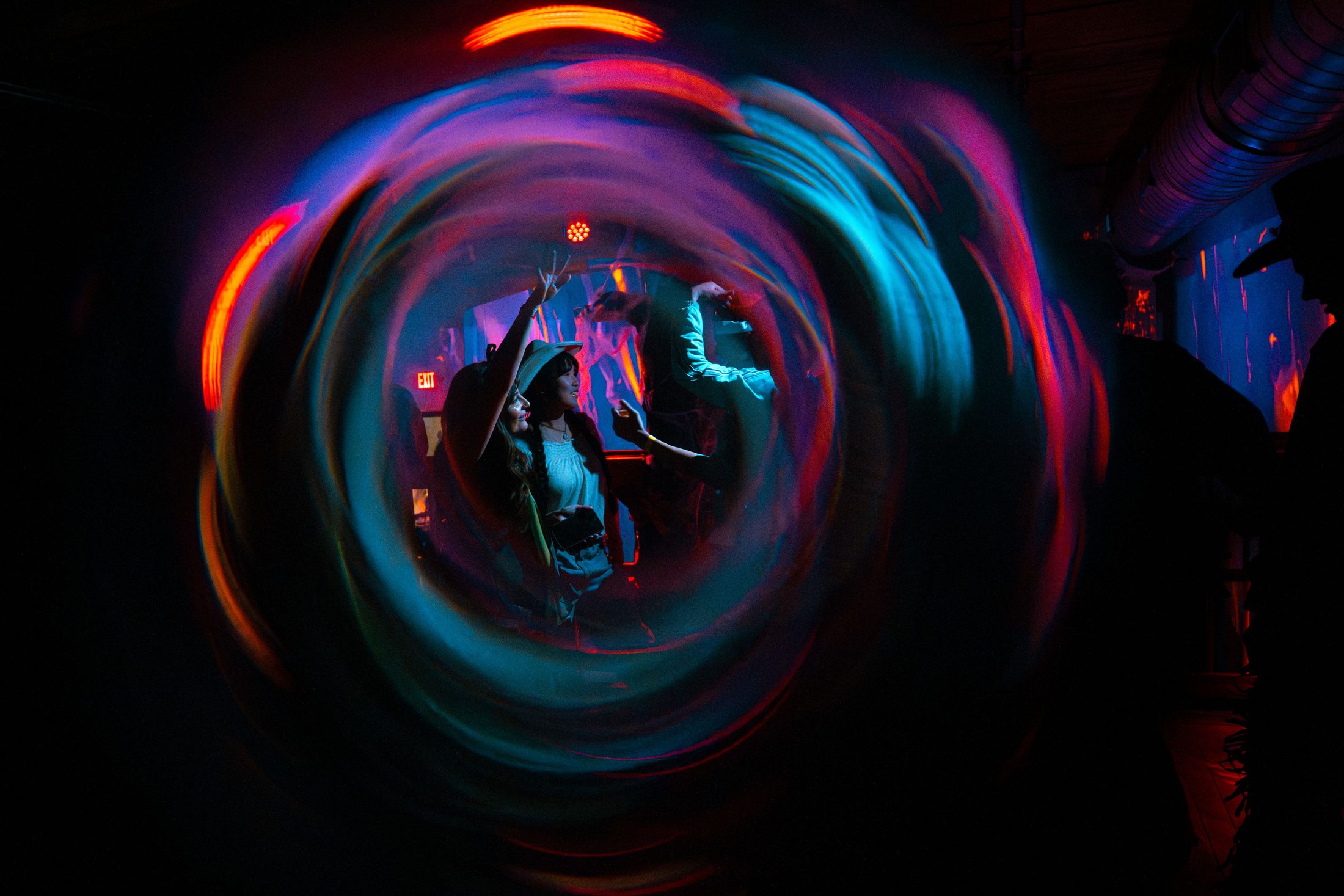dancers seen through a tunnel of light trails at a black label radio show