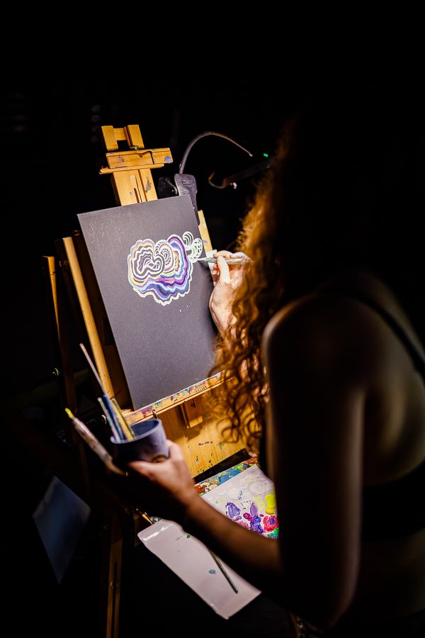 a live painter at the easel during a black label radio show